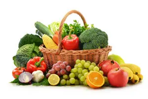 A basket of fresh fruits and vegetables on the table.